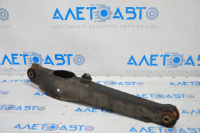 The lower rear right control arm of a Jeep Compass 11-16 is rusty.