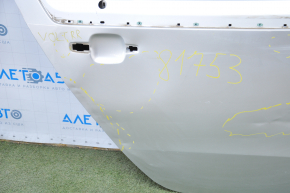 The bare rear right door of a Chevrolet Volt 11-15 silver is dented.