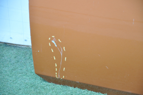 The front left door of a Nissan 350z orange A53 is bare and dented at the bottom.