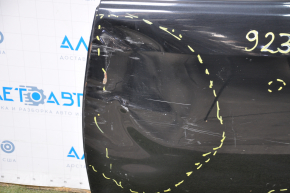 The bare rear left door of a Toyota Camry v40 is black and dented.