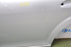 The rear left door of a Mercedes W221 long silver is bare, the bottom is dented, and the bumps are missing.