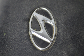 The steering wheel airbag on the driver's side of the Hyundai Sonata 11-15 has a dent on the badge.