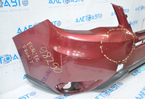 The front bumper of a Subaru Forester 14-16 SJ pre-rest red is dented, has tears, broken fasteners, and scratches.