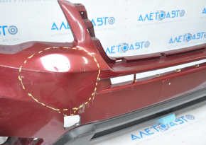 The front bumper of a Subaru Forester 14-16 SJ pre-rest red is dented, has tears, broken fasteners, and scratches.