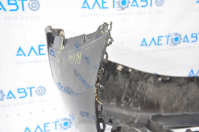 Bare front bumper for a 14-16 Nissan Rogue without a license plate, black, dented, with tears, broken fasteners, filed down, and scratches.