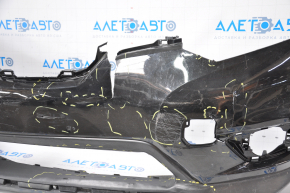 Bare front bumper for a 14-16 Nissan Rogue without a license plate, black, dented, with tears, broken fasteners, filed down, and scratches.