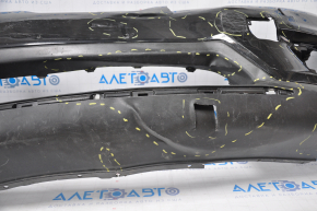Bare front bumper for a 14-16 Nissan Rogue without a license plate, black, dented, with tears, broken fasteners, filed down, and scratches.