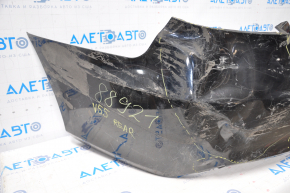 The rear bumper of a Toyota Camry V55 15-17 USA is black and dented, torn, and has broken fasteners.