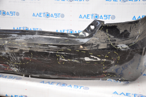 The rear bumper of a Toyota Camry V55 15-17 USA is black and dented, torn, and has broken fasteners.