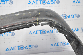 The rear bumper of a Toyota Camry V55 15-17 USA is black and dented, torn, and has broken fasteners.