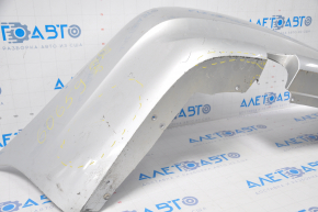 The rear bumper of a BMW 335i e92 07-10 silver is dented, sawed, and has broken fasteners.