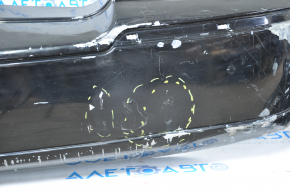 The rear bumper of a 98-11 Lincoln Town Car is bare and black, dented, with torn fasteners and missing right molding.