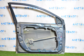 The front left door of a Hyundai Sonata 15-19, turquoise, has a dent in the front.