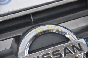 Nissan Alltima 2005 USA radiator grille has chrome breakage, tears, broken fasteners, torn guides, and a bump on the emblem.
