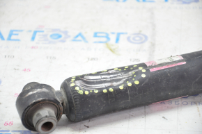 The rear left shock absorber of a Toyota Prius V 12-14 is dented.
