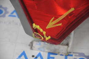 The left inner trunk lid light of a Toyota Camry V55 15-17 USA has a chipped glass corner.