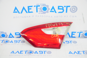 The corner of the inner right trunk lid light of a Ford Focus mk3 11-14 pre-restoration 4D is broken.