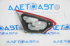 The corner of the inner right trunk lid light of a Ford Focus mk3 11-14 pre-restoration 4D is broken.