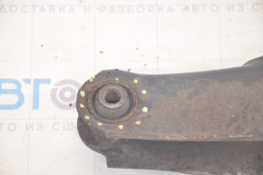The lower rear left control arm of a Dodge Journey 11-20 has a torn silent block and is rusty.