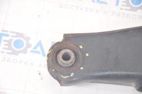 The lower rear left control arm of a Dodge Journey 11-20 has a torn silent block and is rusty.