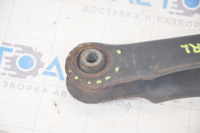 The lower rear left control arm of a Dodge Journey 11-20 has a torn silent block and is rusty.
