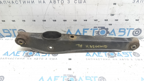 The lower rear left control arm of a Jeep Compass 11-16 is rusty and the silent blocks are torn.