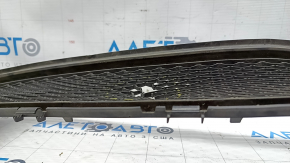 The lower grille of the front bumper of the Mercedes CLA 17-19 is dented, cracks