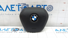 The airbag in the driver's steering wheel of a BMW 3 G20 19-24 is black and the mount is broken.