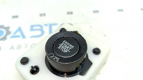 The ignition start-stop button on a Jeep Cherokee KL 14-23 has peeling paint and cracks.
