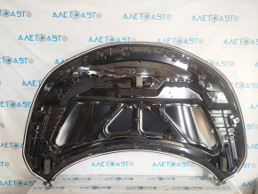 The hood of a 2017-2019 Nissan Rogue Sport is bare steel and dented.