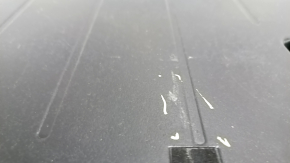 The trunk floor of a 12-14 Toyota Prius V is dark gray, scratches, and needs cleaning.