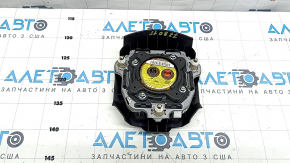 The driver's side airbag in the steering wheel of a Subaru Forester 17-18 SJ is black, scratched, and has a rusty piston.