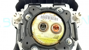 The driver's side airbag in the steering wheel of a Subaru Forester 17-18 SJ is black, scratched, and has a rusty piston.
