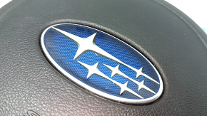 The driver's side airbag in the steering wheel of a Subaru Forester 17-18 SJ is black, scratched, and has a rusty piston.