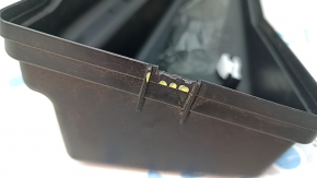 The underhood fuse box cover, left, for a Lexus ES300h 13-15, has a broken mount.