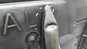The left engine guard of a Toyota Avalon 13-15 is dented and torn.