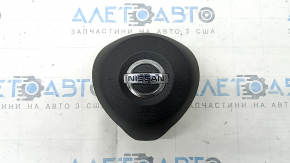 The driver's side steering wheel airbag for a Nissan Rogue 17-20 is black, has scratches, and is rusty.