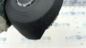 The driver's side steering wheel airbag for a Nissan Rogue 17-20 is black, has scratches, and is rusty.