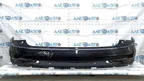 The bare rear bumper, upper part of the Audi Q3 8U 16-18, under 2 parking sensors, is dented, scratched, and cracked.
