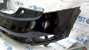 The bare rear bumper, upper part of the Audi Q3 8U 16-18, under 2 parking sensors, is dented, scratched, and cracked.