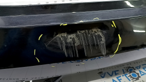 The bare rear bumper, upper part of the Audi Q3 8U 16-18, under 2 parking sensors, is dented, scratched, and cracked.