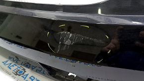 The bare rear bumper, upper part of the Audi Q3 8U 16-18, under 2 parking sensors, is dented, scratched, and cracked.