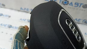 The steering wheel airbag for the driver's side of the Audi Q7 4L 10-15 is black, the chrome is peeling, and there is a scratch.