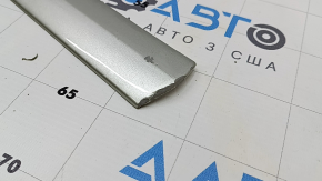 The lower front right door trim for the Lexus RX300 RX330 RX350 RX400h 04-08 is missing a guide and has scratches.