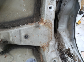 The quarter panel of the rear right Toyota Camry v40 is sawed off, silver, rusty, with bumps.