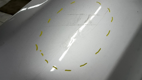 The rear bumper of a Toyota Camry V40 hybrid is bare, silver, pressed, and has cracks.