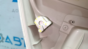 The front right door panel of the VW Passat b7 12-15 USA is beige, with a beige insert, the armrest is beige, dented, the fasteners are broken