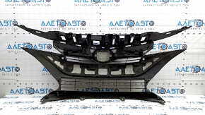 The radiator grill of a Toyota Prius 50 Prime 17-19 under parking sensors is cracked and dented.
