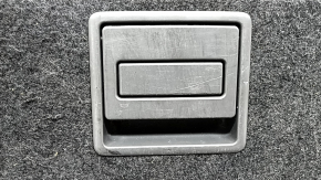 The trunk floor of a Toyota Prius V 15-17 is dark gray, with scratches on the handle.