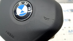 The steering wheel airbag for the driver's side of a BMW 3 G20 19-24 is black, with a rusty squib and scratches.